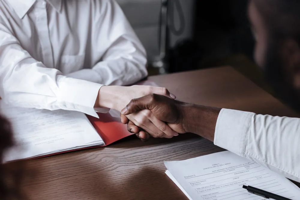Two people shaking hands to close a deal